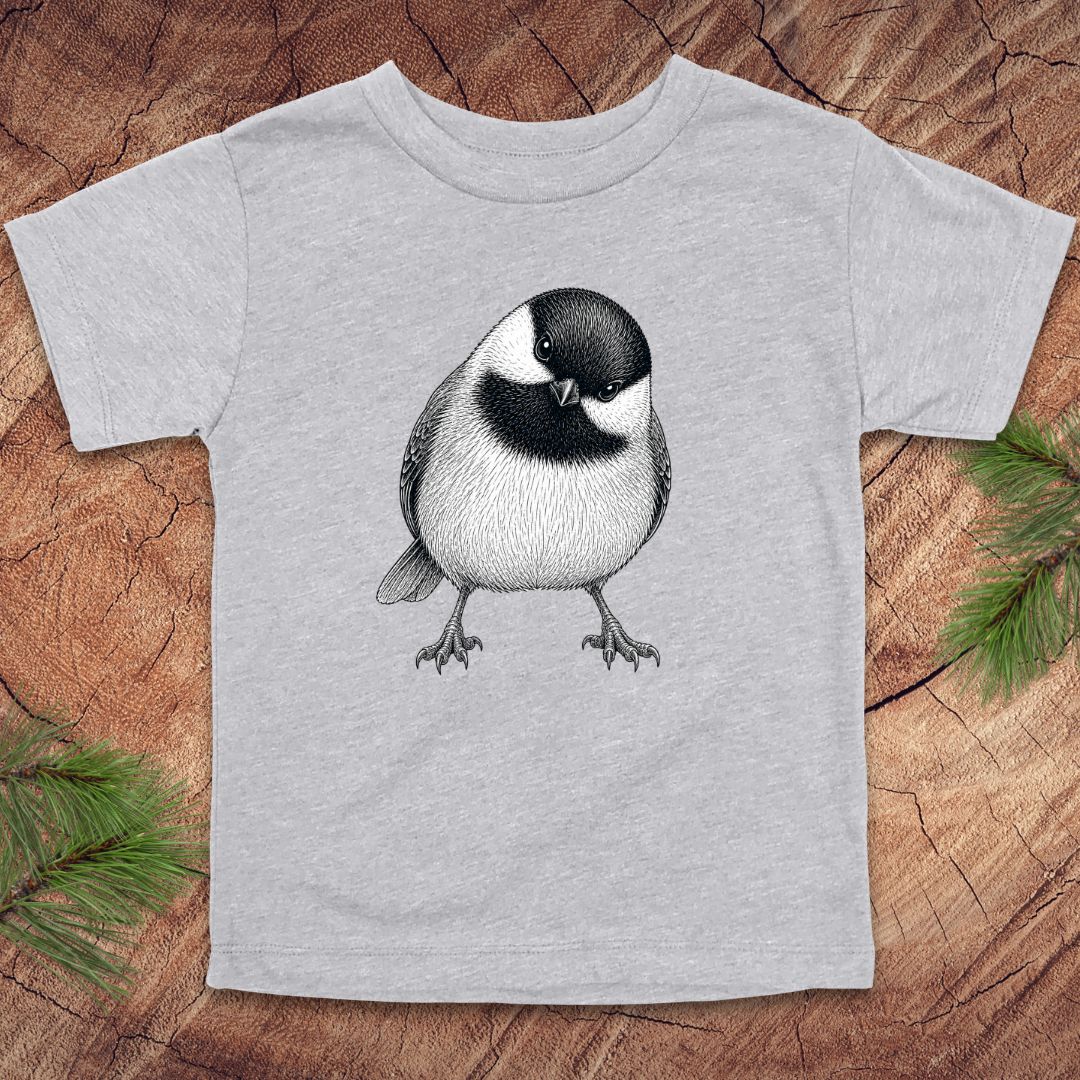 Gray toddler t-shirt with a chickadee design on a wooden surface