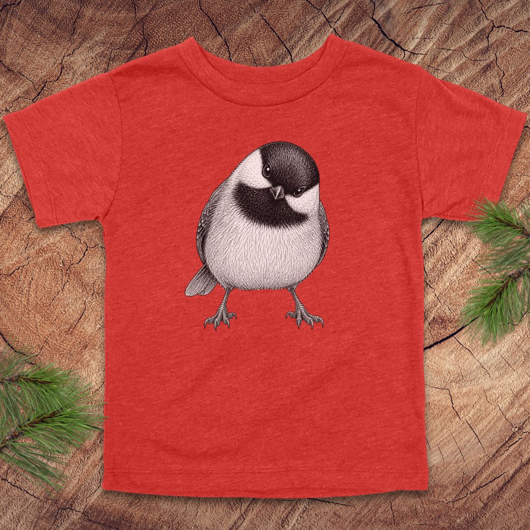 Red toddler t-shirt with a chickadee design on a wooden surface