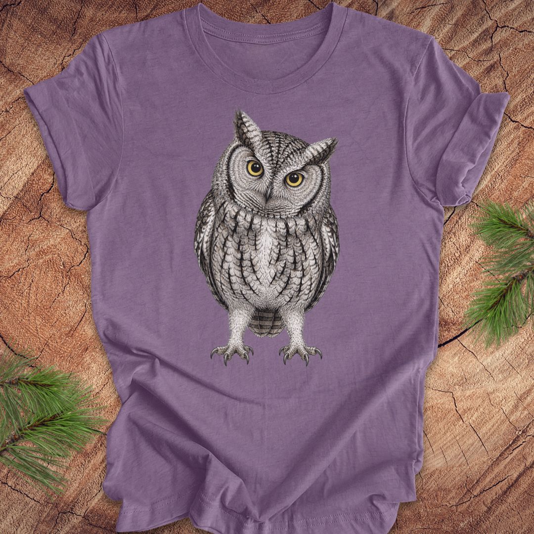 Purple t-shirt with an owl design on a wooden surface