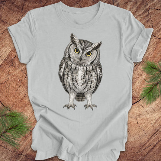 Gray t-shirt with an owl design on a wooden surface