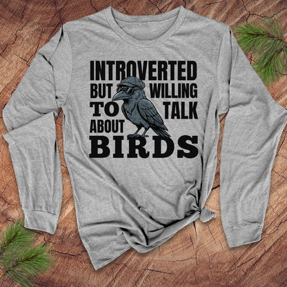 Gray long-sleeve shirt with a graphic of a bird and text on a wooden surface.