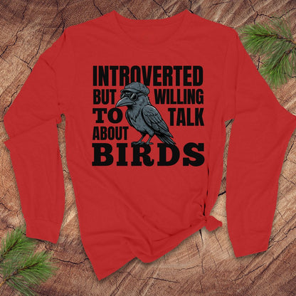 Red long-sleeve shirt with a black crow graphic and text on a wooden surface.