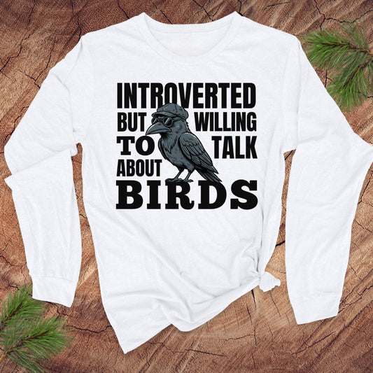White long-sleeve tshirt with a crow graphic and text on a wooden surface