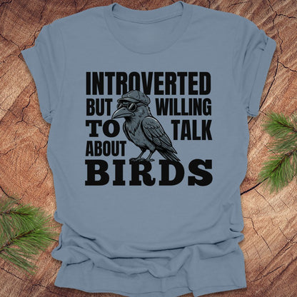 Blue t-shirt with a graphic of a bird and text on a wooden surface