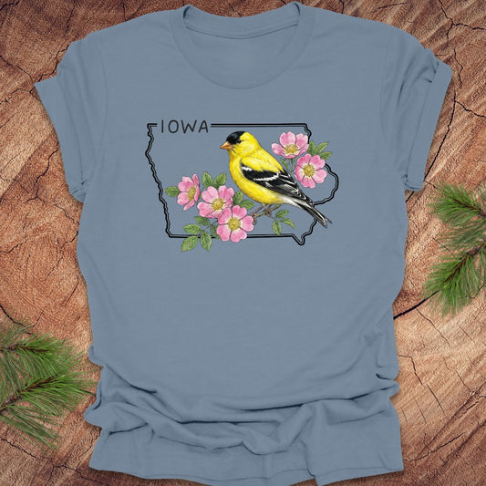 Steel Blue t-shirt with the outline of the state of Iowa with state bird and flower, goldfinch and rose, on a wood background.