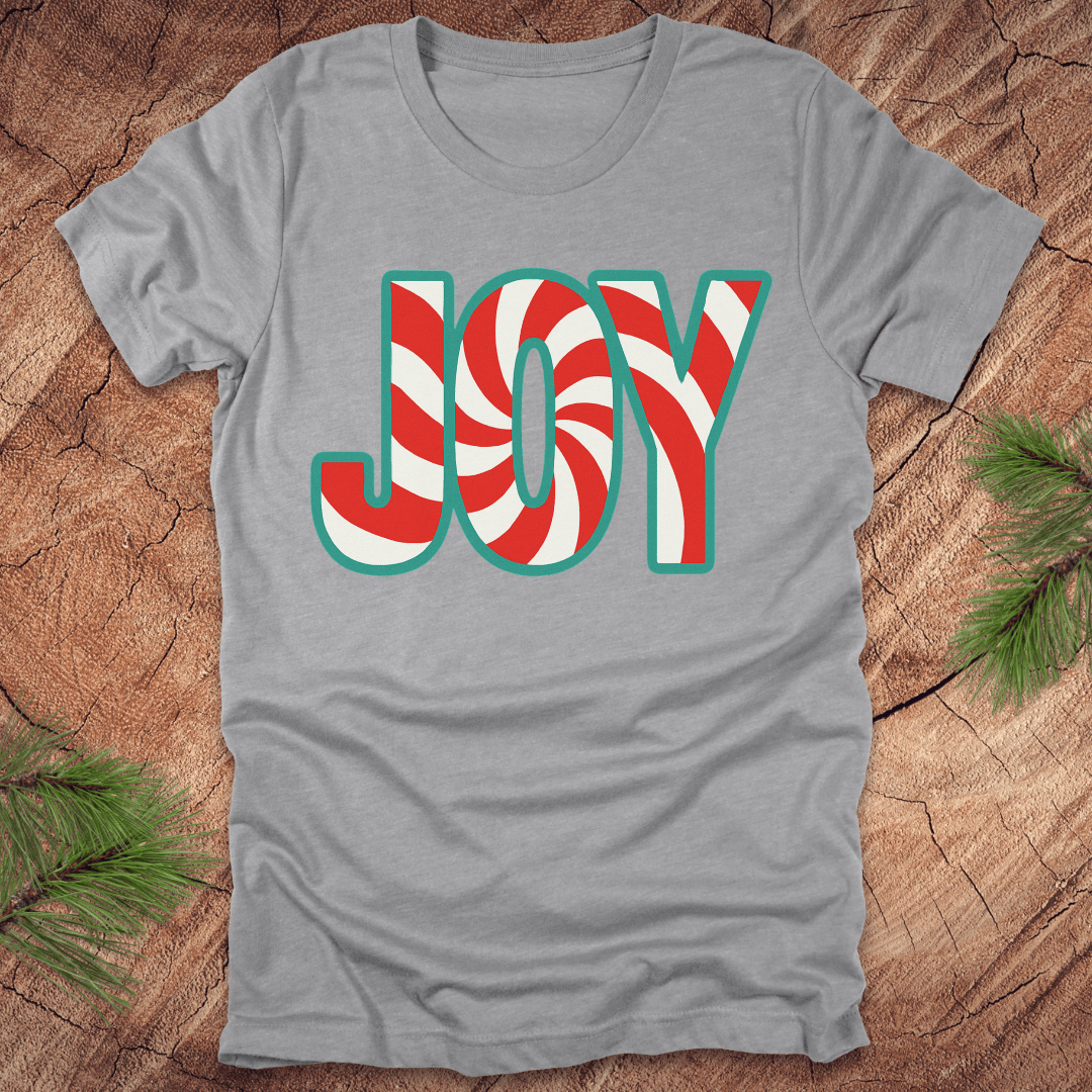 Grey t-shirt with the text, "JOY" in a red and white pattern on a wood background