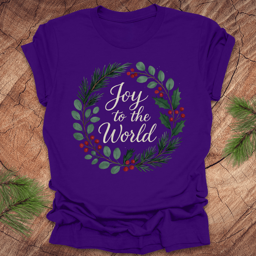 Purple t-shirt with wreath and text, 'Joy to the World' design on a wooden surface