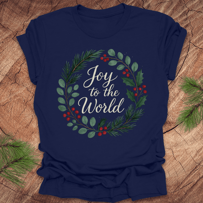 Navy blue t-shirt with wreath and text, 'Joy to the World' design on a wooden surface