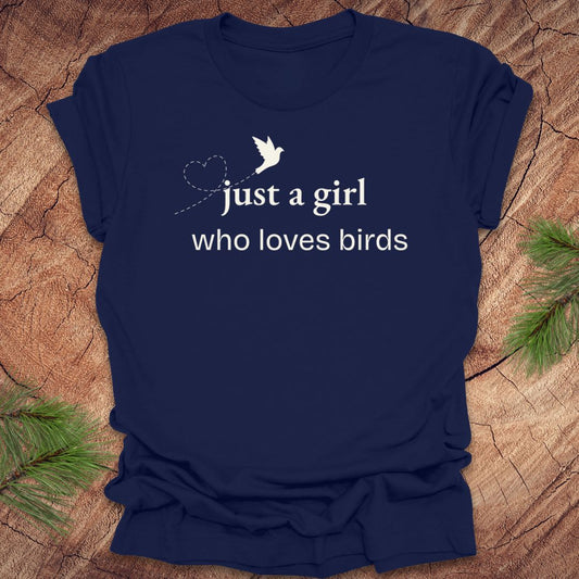 Navy blue t-shirt with 'just a girl who loves birds' text and bird graphic on a wooden surface.