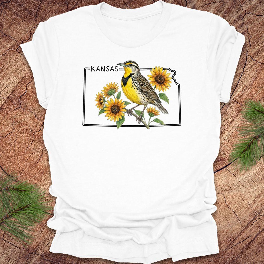 White t-shirt with a graphic of a bird and sunflowers on a wooden surface