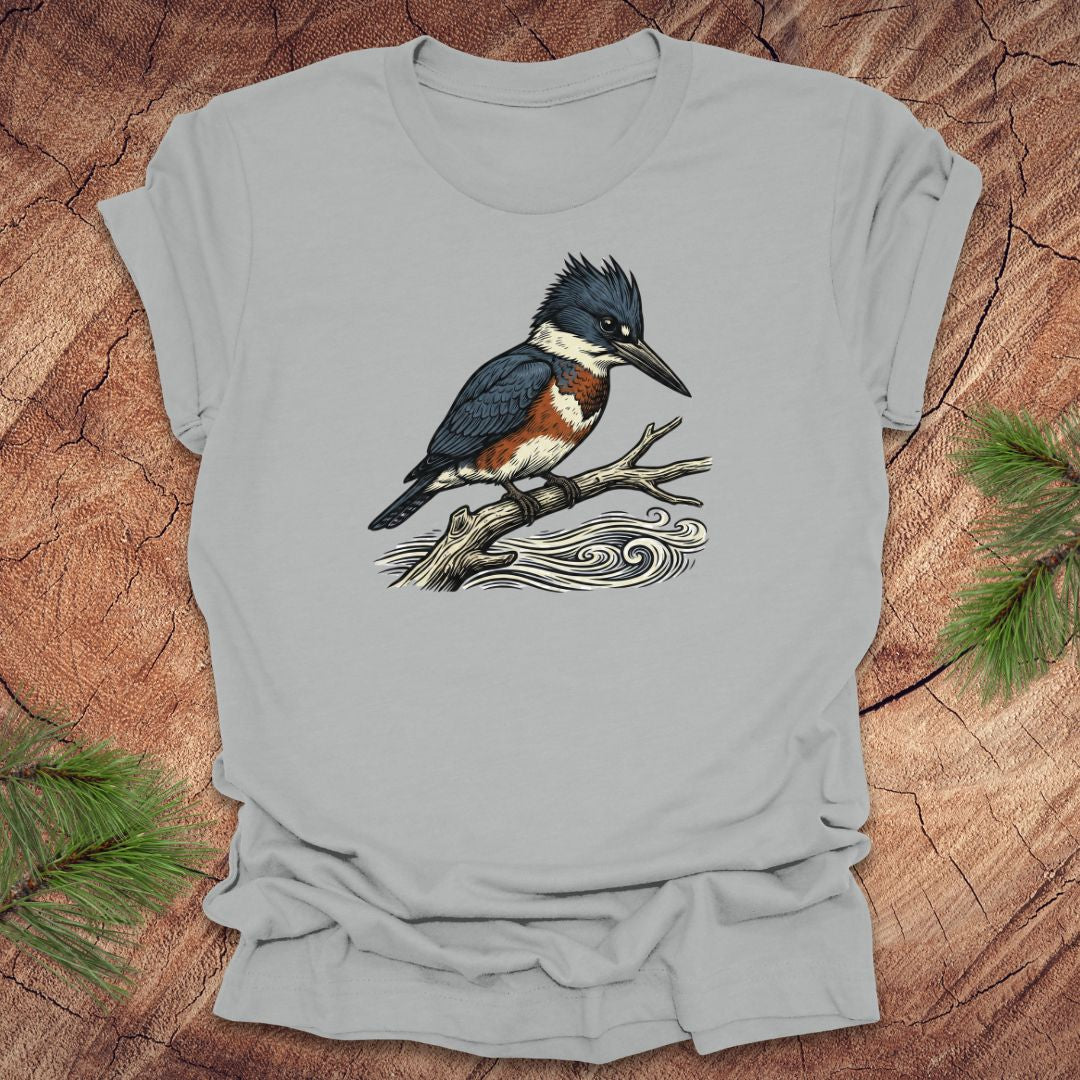 Silver t-shirt with a kingfisher bird design on a wooden surface