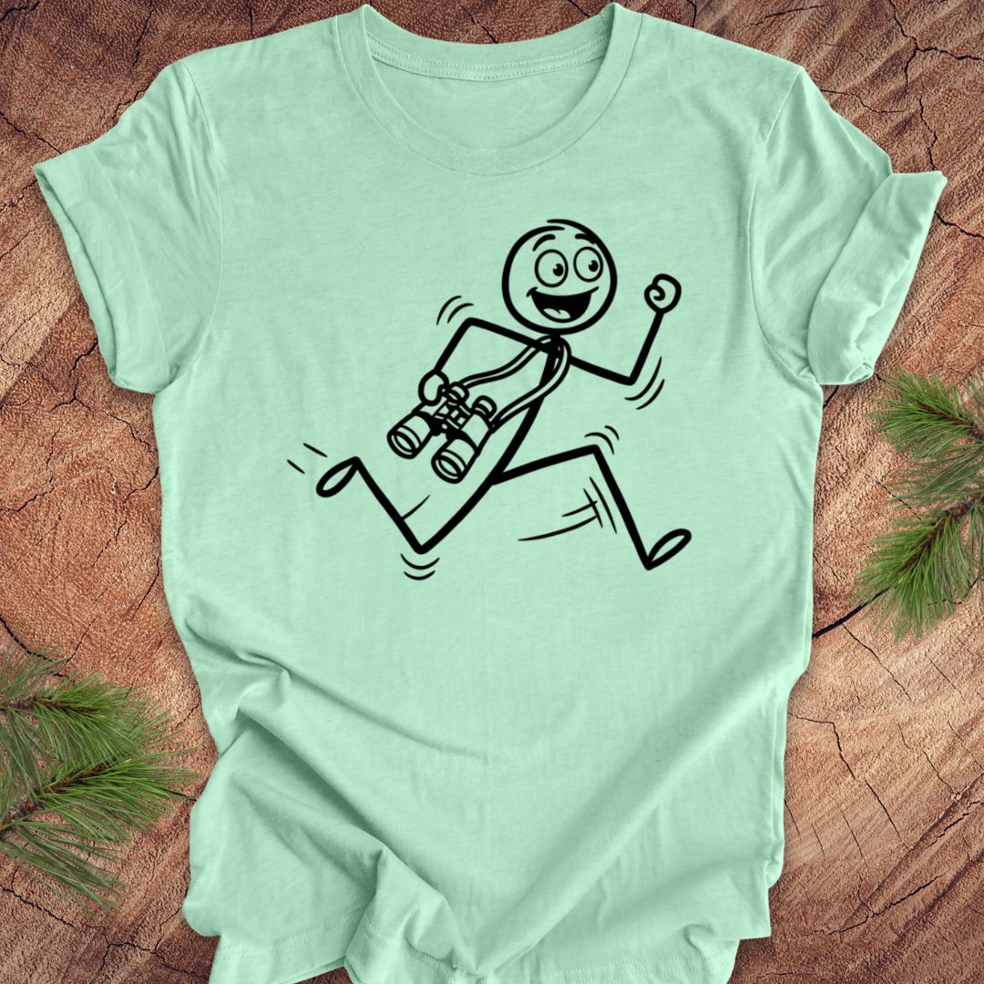 Mint green t-shirt with a stick figure design running with binoculars on a wooden surface