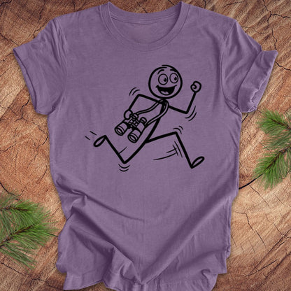 Purple t-shirt with a stick figure design running with binoculars on a wooden surface