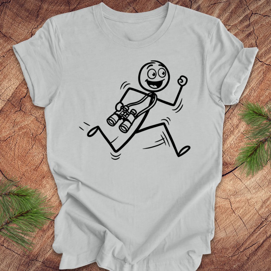 Gray t-shirt with a stick figure design running with binoculars on a wooden surface