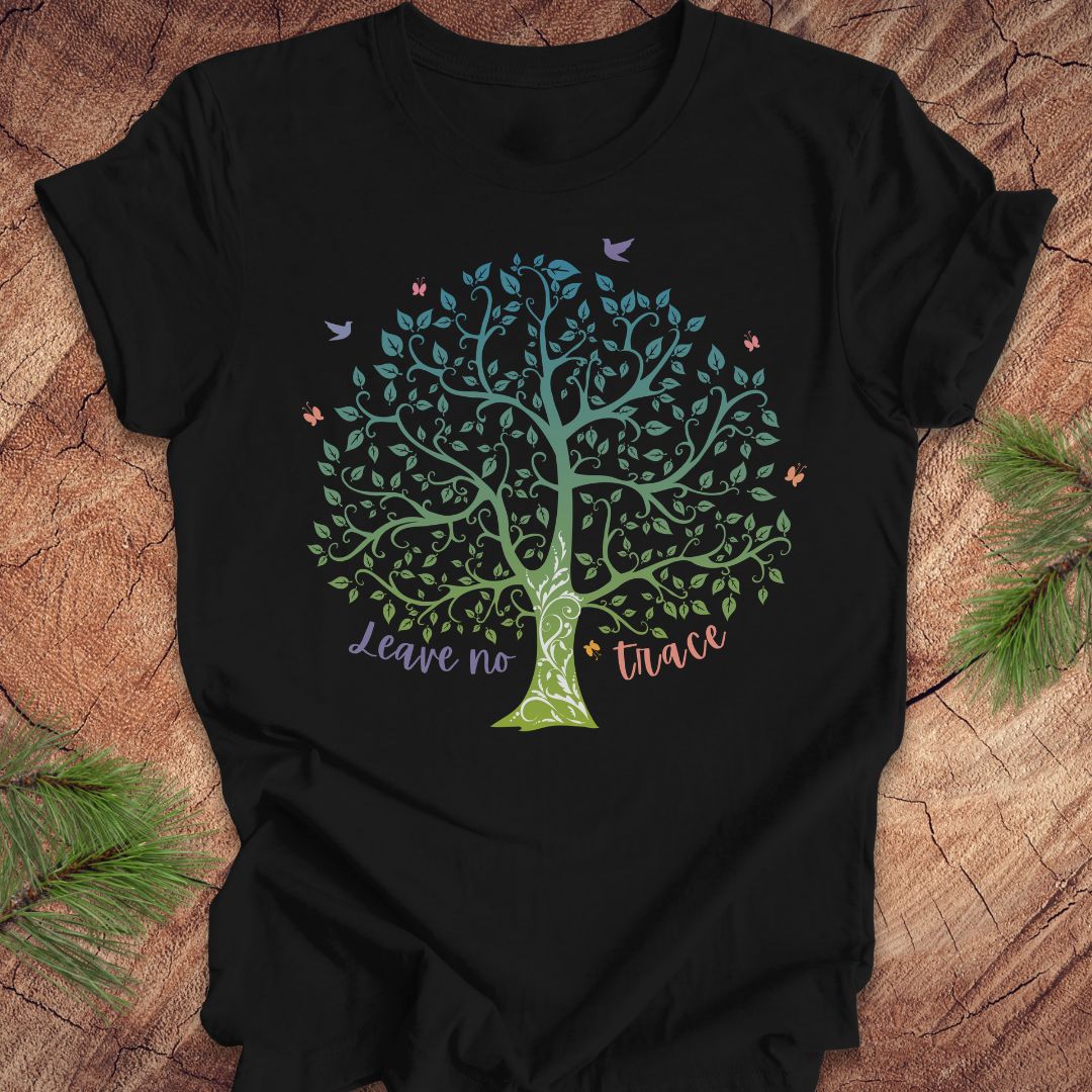 Black t-shirt with a tree design and 'Leave no trace' text on a wooden surface.