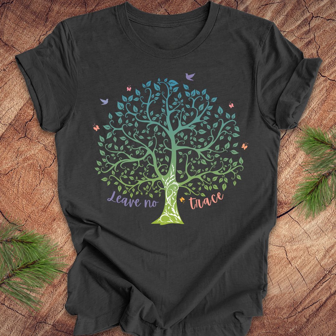 Black t-shirt with a colorful tree design and 'Leave no trace' text on a wooden surface.