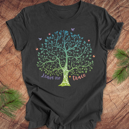 Black t-shirt with a colorful tree design and 'Leave no trace' text on a wooden surface.