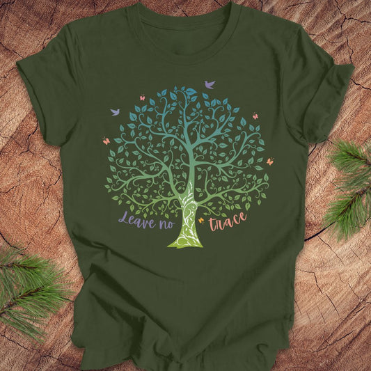 Green t-shirt with a tree design and 'Leave no trace' text on a wooden surface.