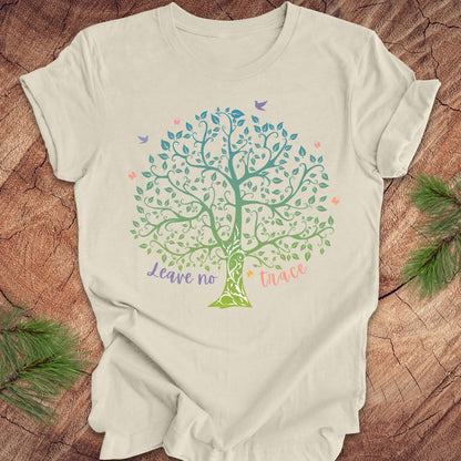 Beige t-shirt with a colorful tree design and text on a wooden surface.