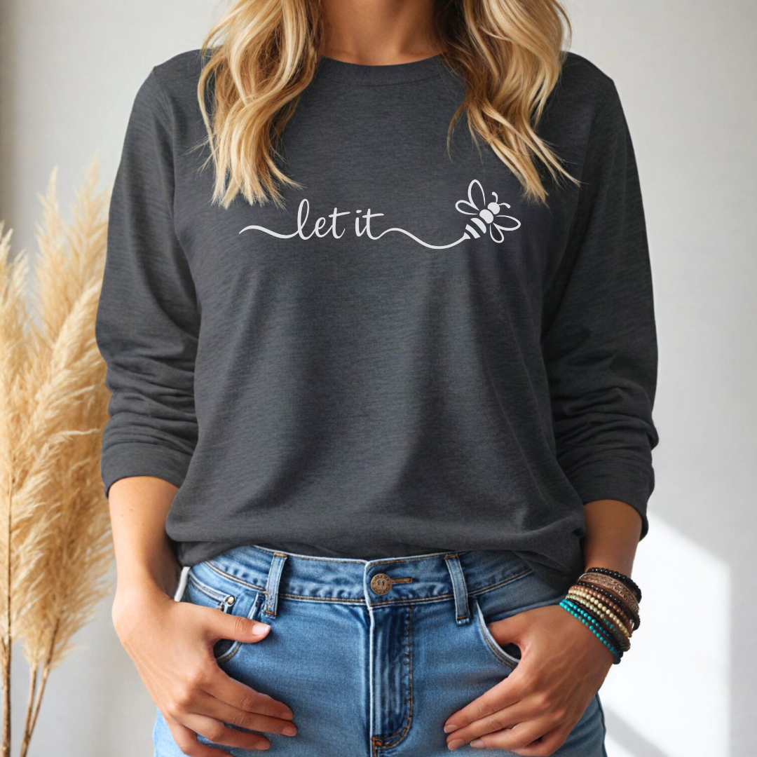 Person wearing a dark gray long-sleeve tshirt with 'let it' text and bee graphic, standing against a neutral background.