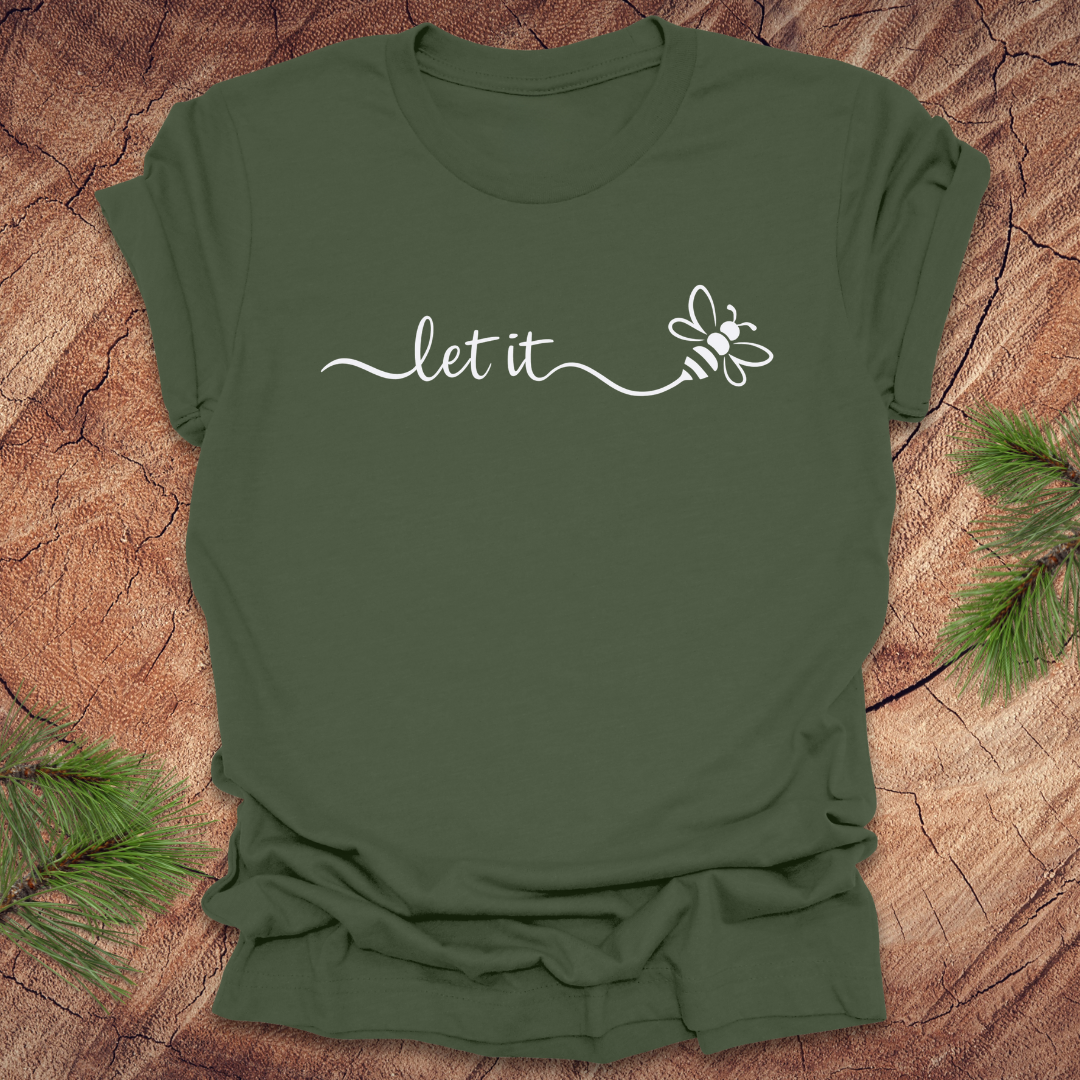 Green t-shirt with 'let it' and bee design on a wooden surface