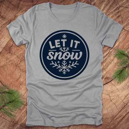 Gray t-shirt with 'Let It Snow' design on a wooden surface