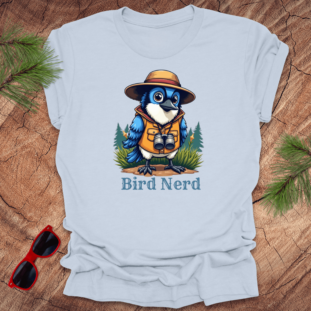Light blue t-shirt with an animated blue jay in birdwatching gear with "bird nerd" text on a wood background.