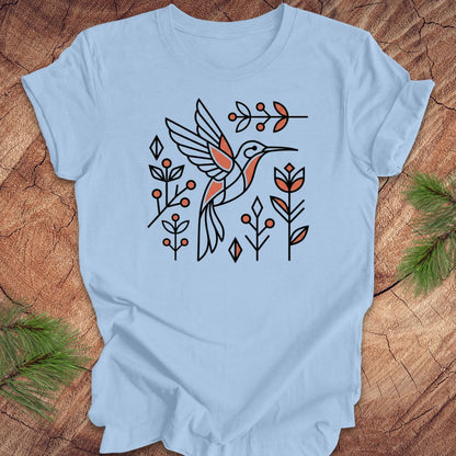 Light blue t-shirt with a hummingbird design on a wooden surface