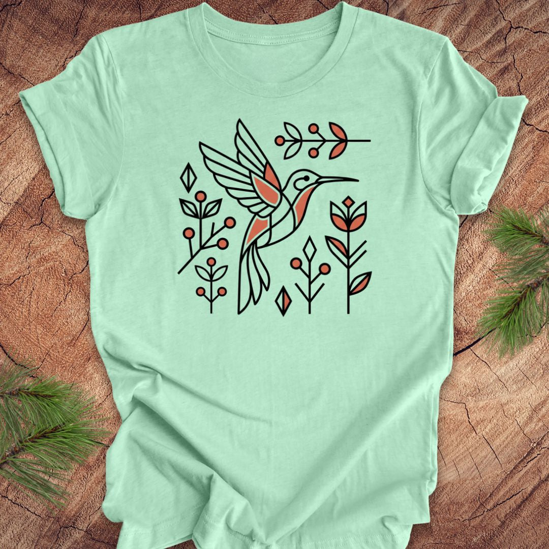 Mint green t-shirt with a hummingbird design on a wooden surface