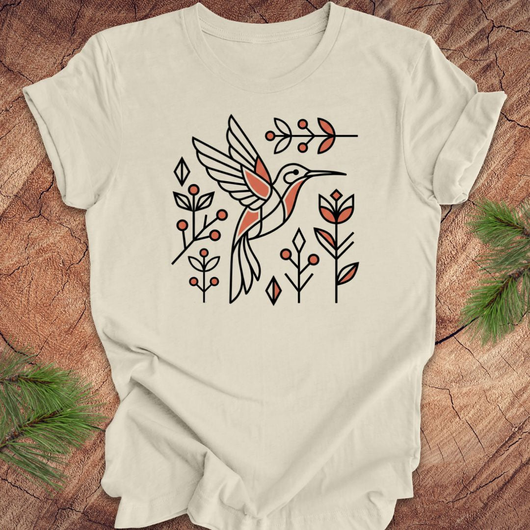 Beige t-shirt with a hummingbird design on a wooden surface