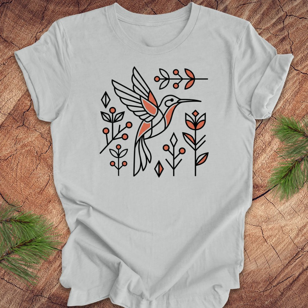 Gray t-shirt with a hummingbird design on a wooden surface
