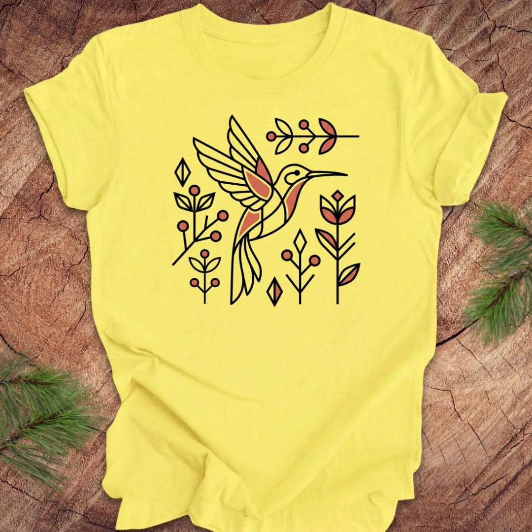 Yellow t-shirt with a hummingbird design on a wooden surface