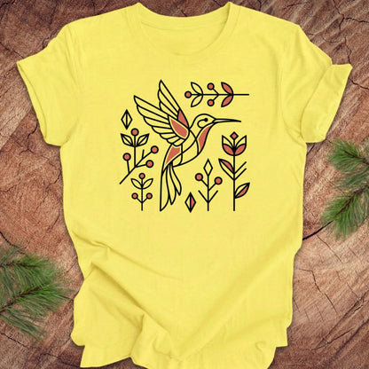 Yellow t-shirt with a hummingbird design on a wooden surface