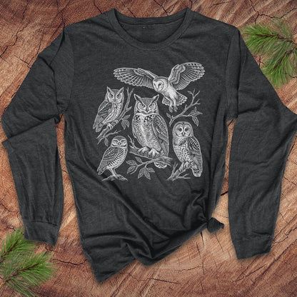 Dark gray long-sleeve tshirt with white owl design on a wooden surface