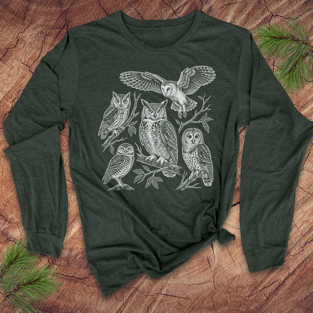 Green long-sleeve tshirt with white owl design on a wooden surface
