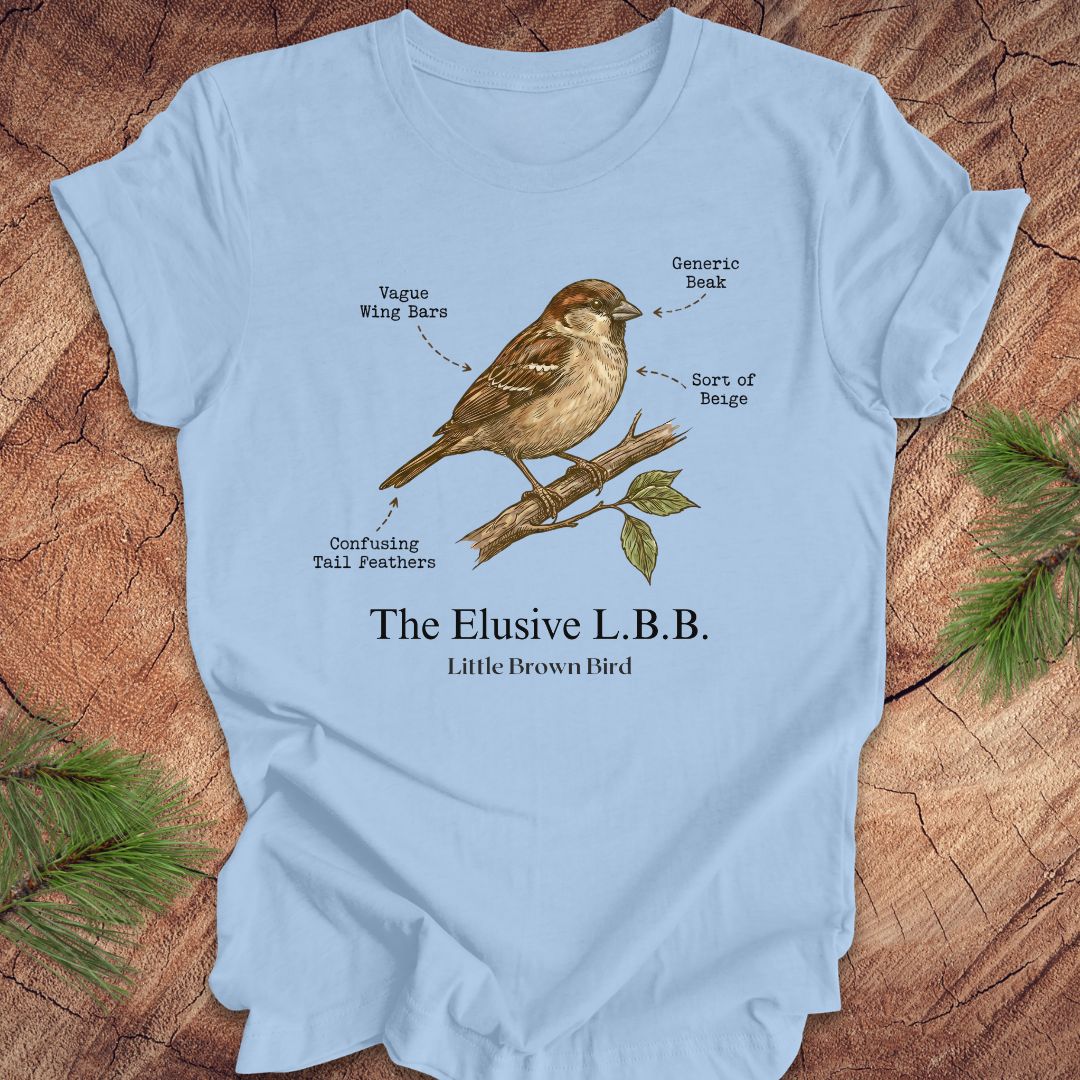 Light blue t-shirt with a bird illustration and text on a wooden surface