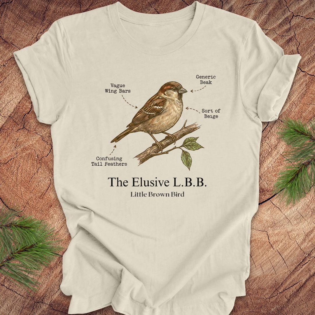 Beige t-shirt with a bird illustration and text on a wooden surface