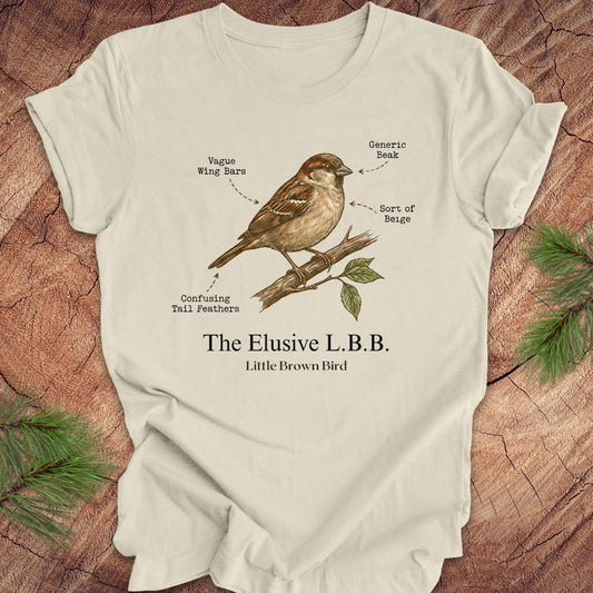 Beige t-shirt with a bird illustration and text on a wooden surface