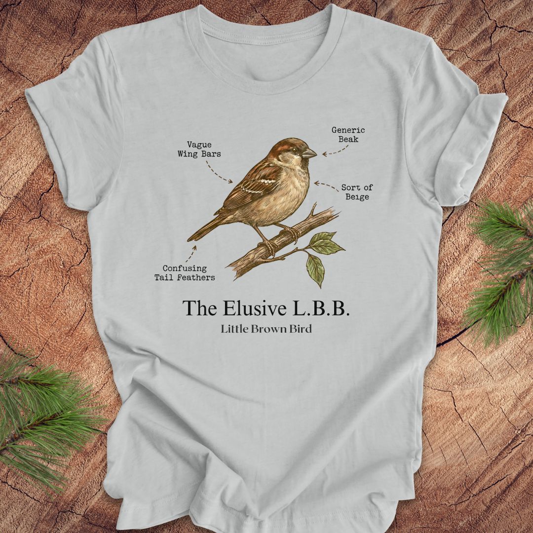 Gray t-shirt with a bird illustration and text on a wooden surface