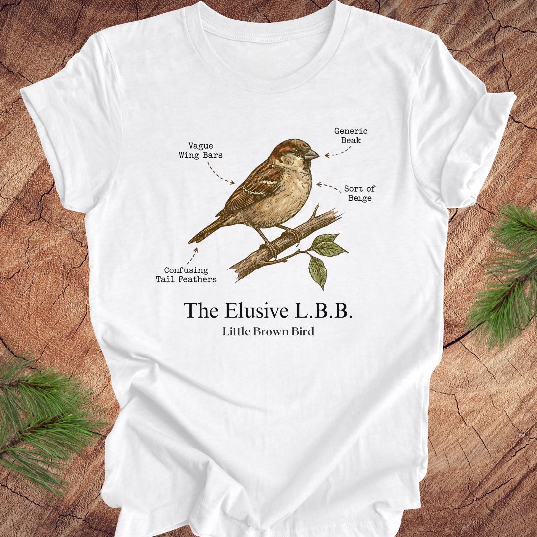 White t-shirt with a bird illustration and text on a wooden surface