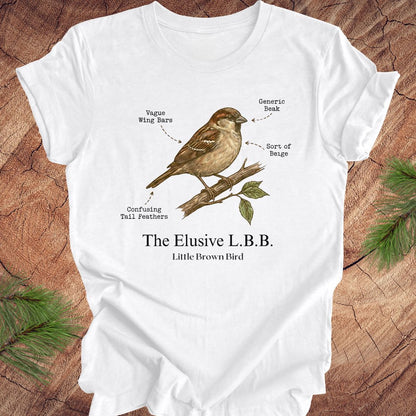 White t-shirt with a bird illustration and text on a wooden surface