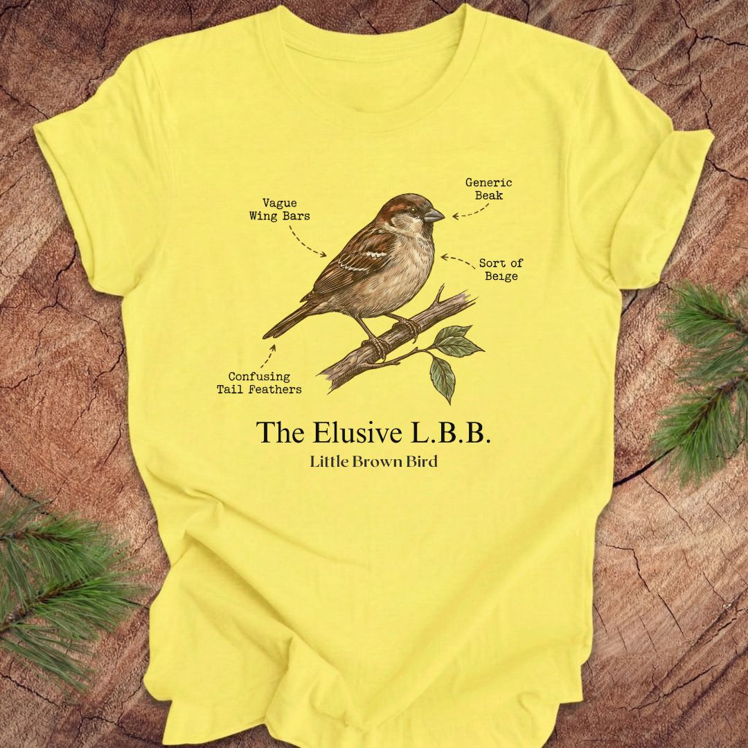 Yellow t-shirt with a bird illustration and text on a wooden surface