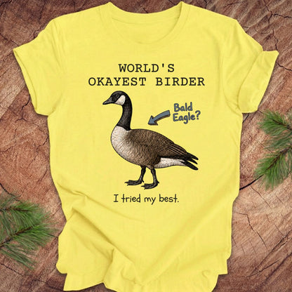 Yellow t-shirt with a goose graphic and text on a wooden surface