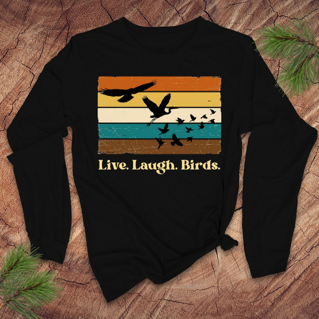 Black long-sleeve shirt with bird design and 'Live. Laugh. Birds.' text on a wooden surface.
