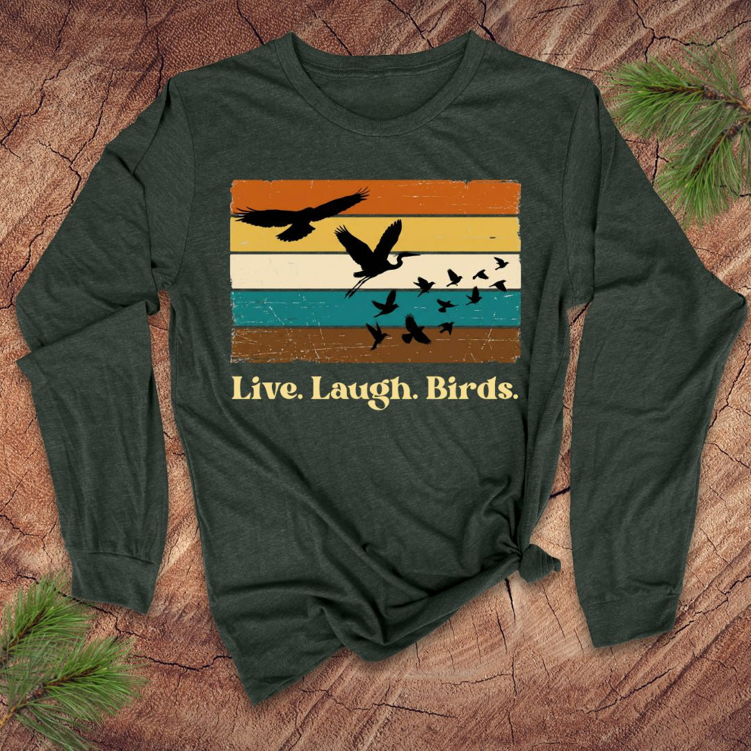 Green long-sleeve shirt with bird graphic and 'Live. Laugh. Birds.' text on a wooden surface.