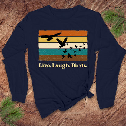 Navy blue long-sleeve shirt with 'Live. Laugh. Birds.' design on a wooden surface.