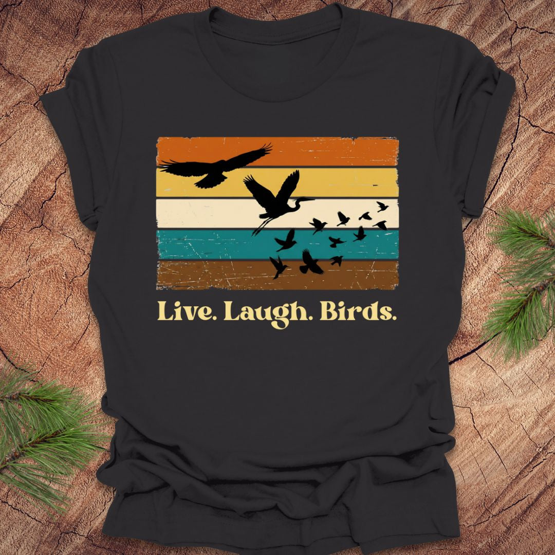 Dark gray t-shirt with bird design and 'Live. Laugh. Birds.' text on a wooden surface.