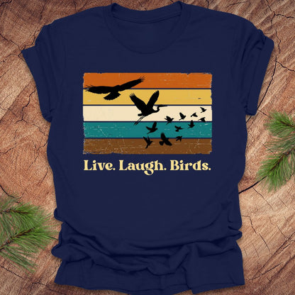 Navy blue t-shirt with bird graphic and 'Live. Laugh. Birds.' text on a wooden surface.