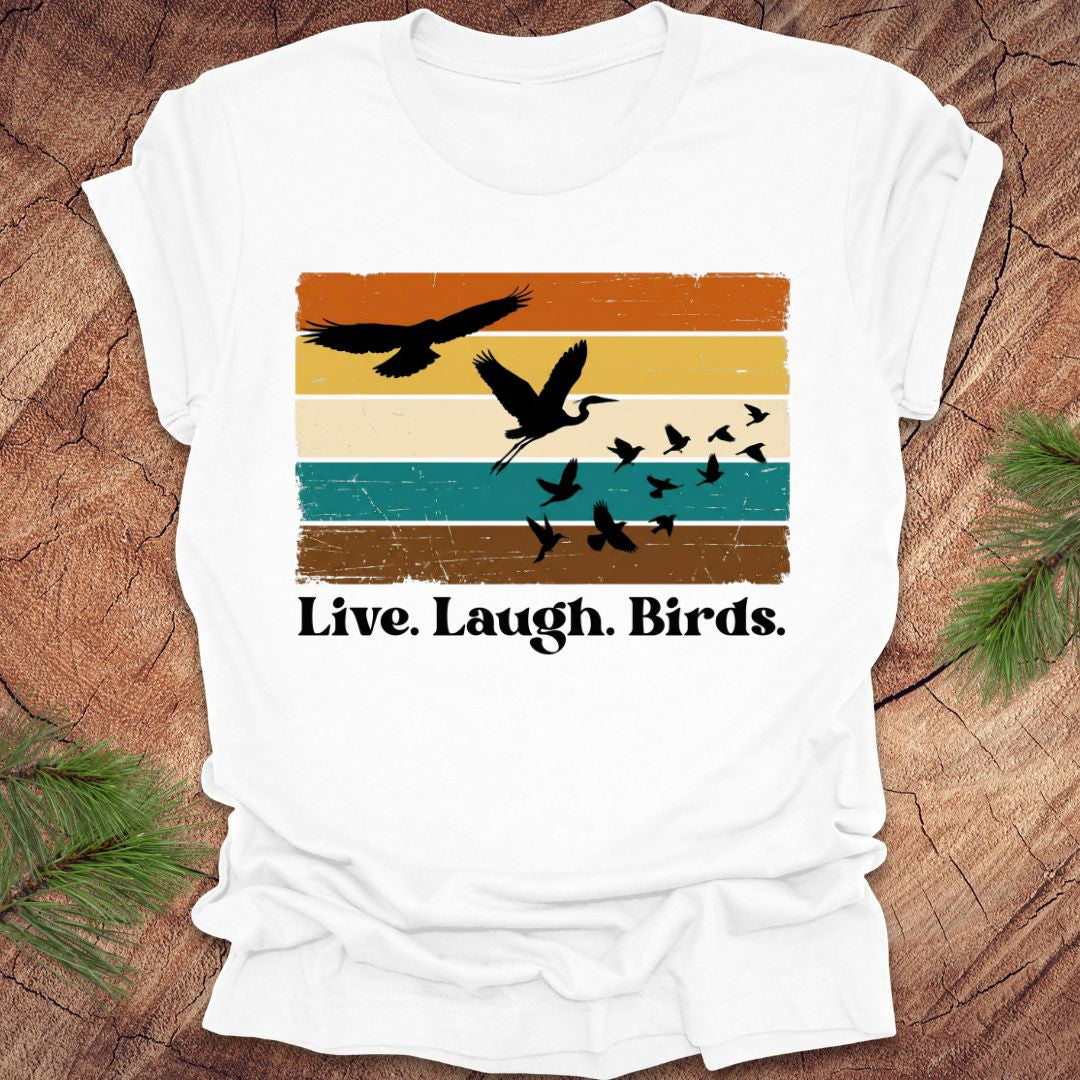 White t-shirt with bird graphic and 'Live. Laugh. Birds.' text on a wooden surface.