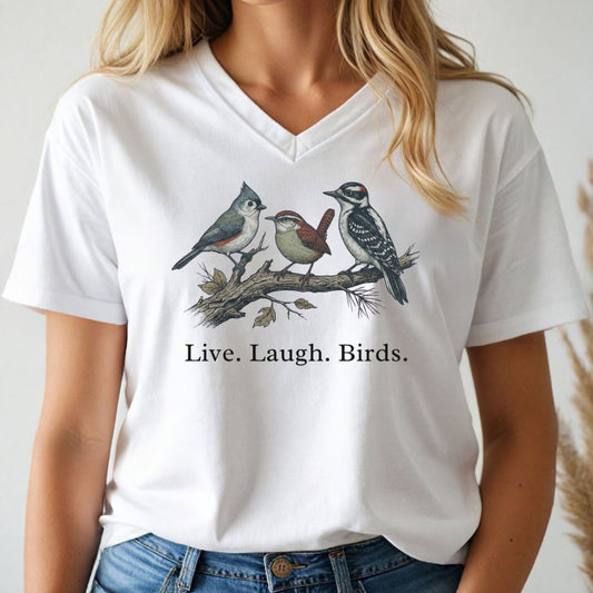White v-neck t-shirt with bird design and 'Live. Laugh. Birds.' text worn by a person.